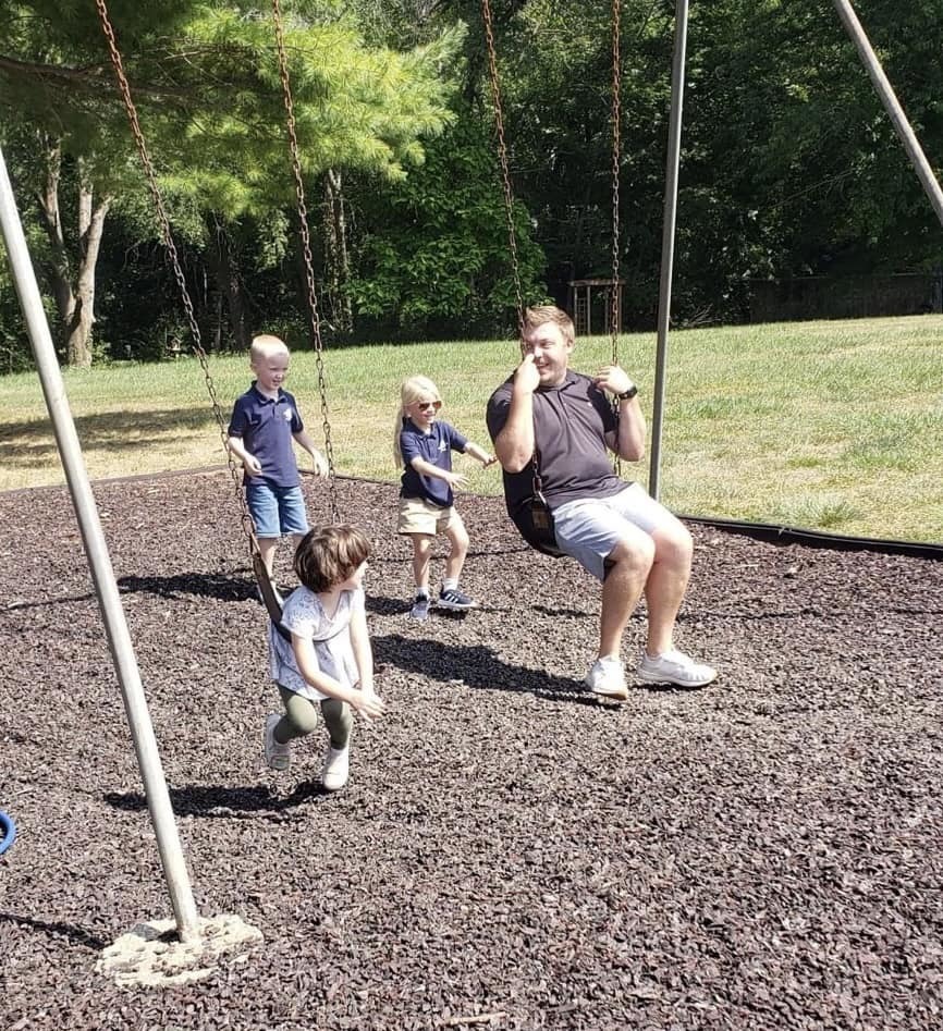Trevor swinging with children